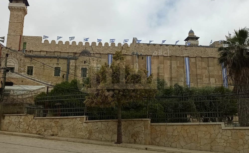 الكيان الصهيوني ومستوطنيه يدنسون الحرم الإبراهيمي برفع علمه على أسواره