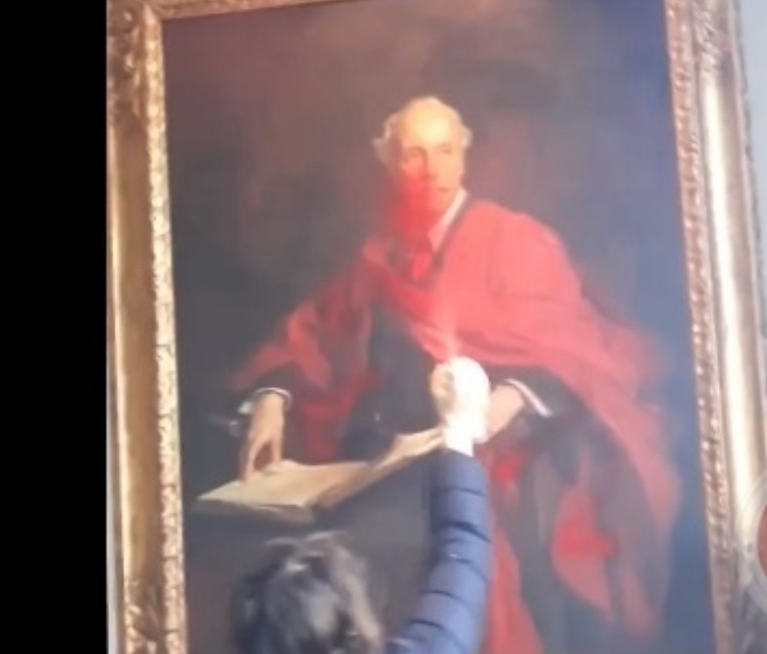 ناشطة تتلف صورة صاحب وعد بلفور بجامعة كامبريدج البريطانية 