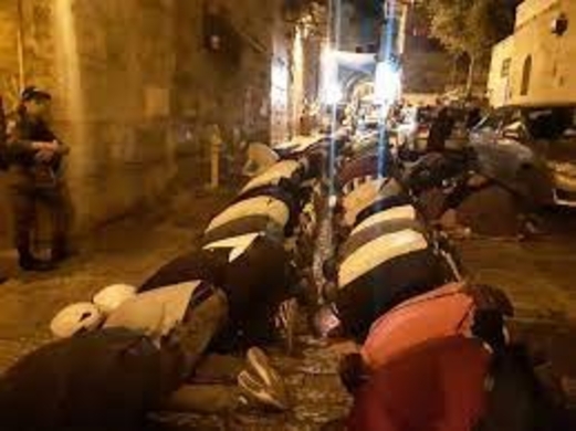 المقدسيون يُصلون العشاء أمام أبواب الأقصى بعد إغلاقه من قوات الاحتلال