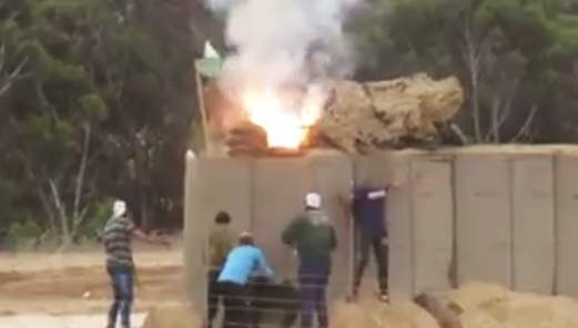 متظاهرين فلسطينيين يحرقون ثكنة عسكرية صهيونية خلال مواجهات ببلدة بيت أمر